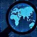 A magnifying glass over a world map highlighting threat origins